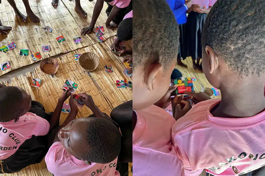 Girls in Malawi sit on the floor and sort colorful cards about human rights into two bowls.